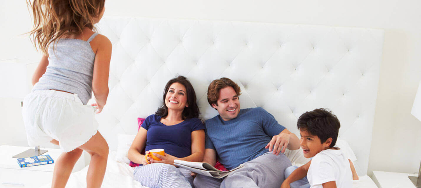 Family relaxing on bed with children