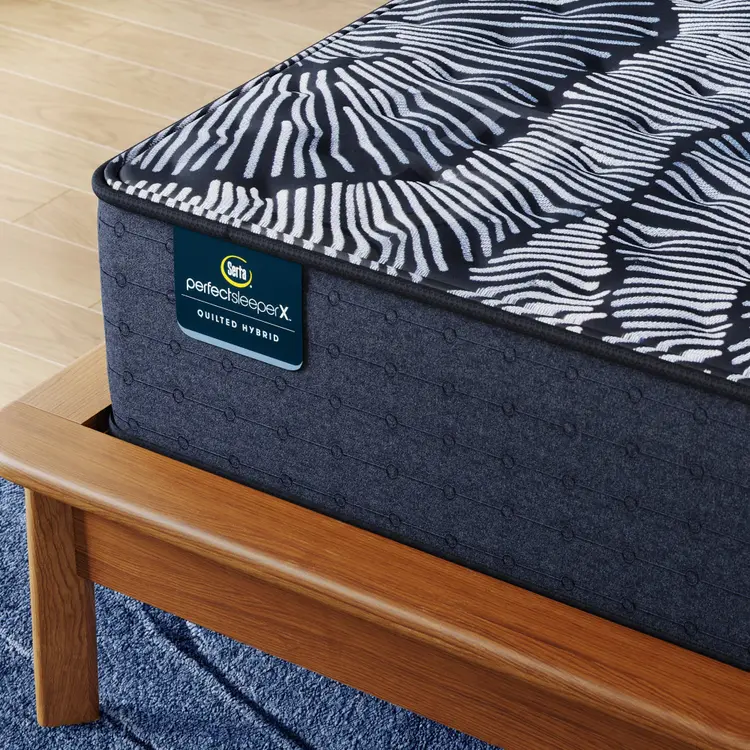 Corner of Perfect Sleeper X Quilted Hybrid Knox Firm Mattress sitting in a brown bedframe || feel: Firm || level: Level 1
