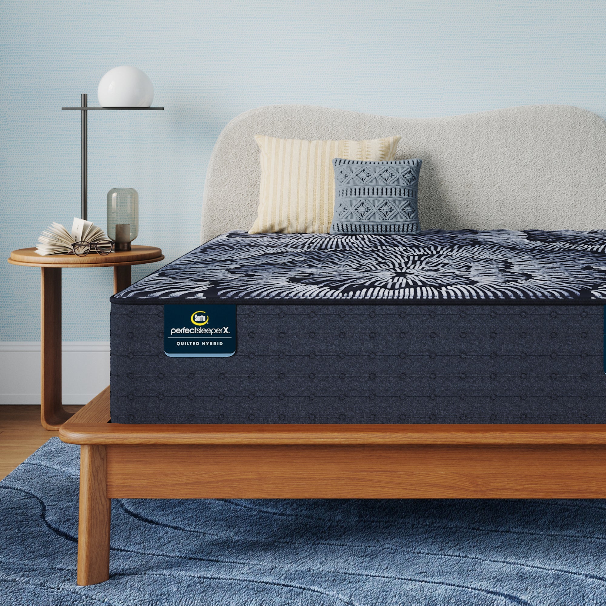 Perfect Sleeper X Quilted Hybrid Excelled Extra Firm Mattress sitting in a brown bedframe || feel: Extra Firm || level: Level 1